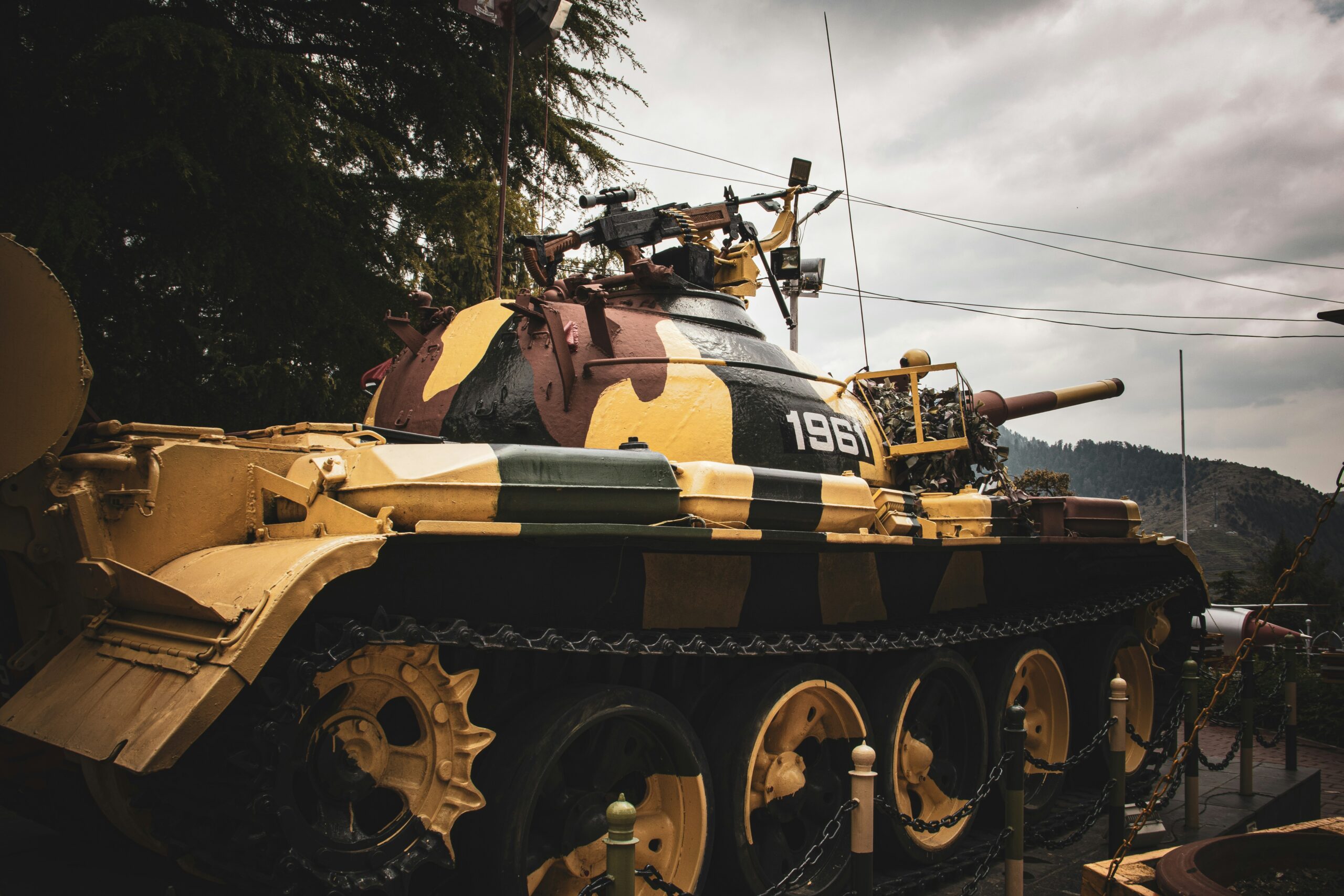 a yellow and black tank sitting on top of a train track