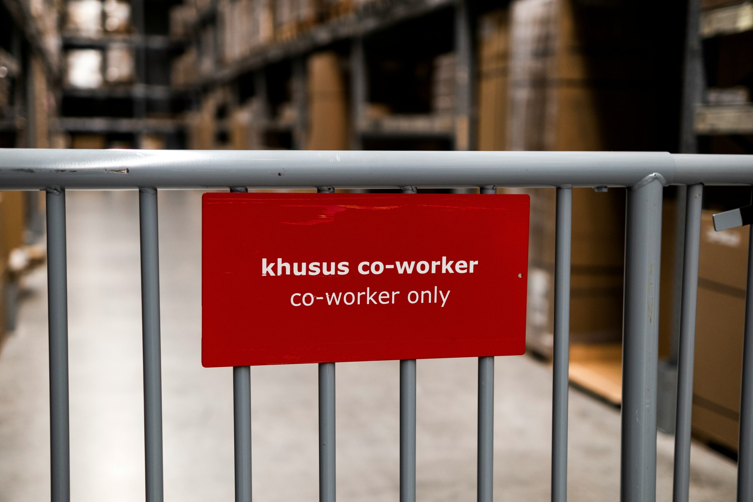 a red sign that is on a metal fence